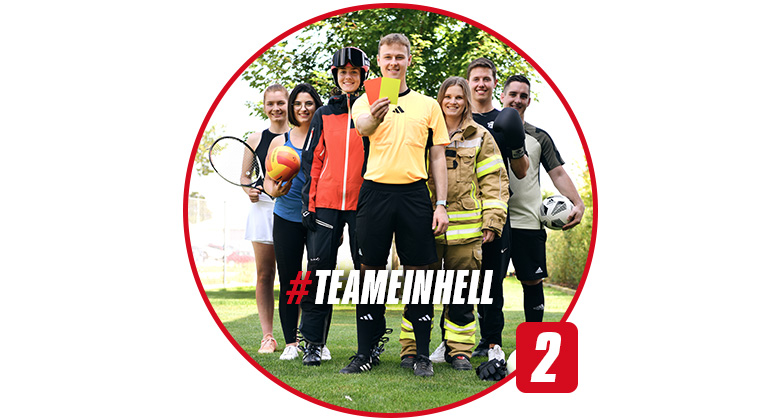 Mehrere Personen in Sport- und Feuerwehrkleidung stehen nebeneinander. Im Bild steht: #TEAMEINHELL.
