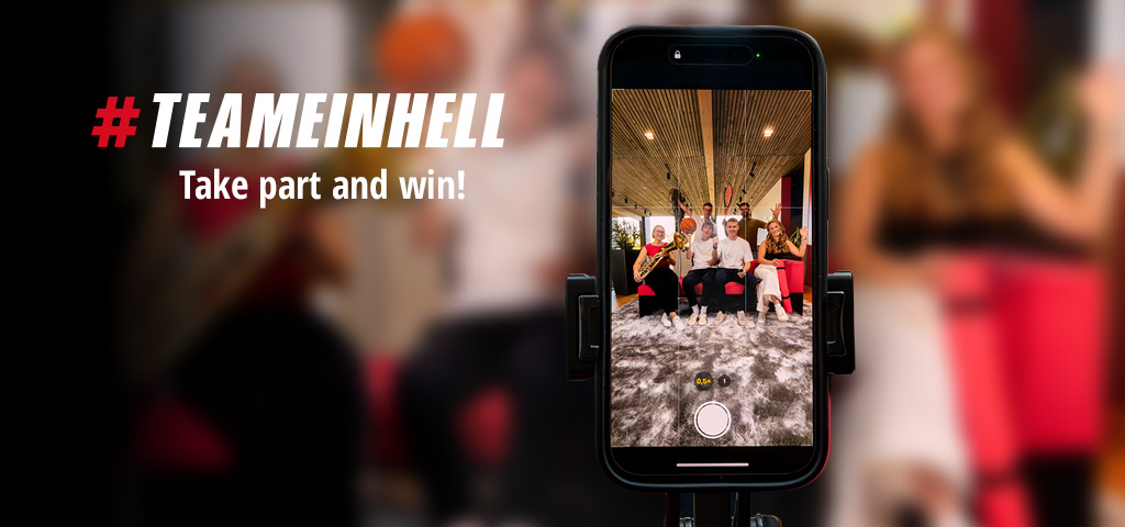 A smartphone shows a group photo of six people with sports equipment and instruments. On the left: "#TEAMEINHELL Take part and win!"